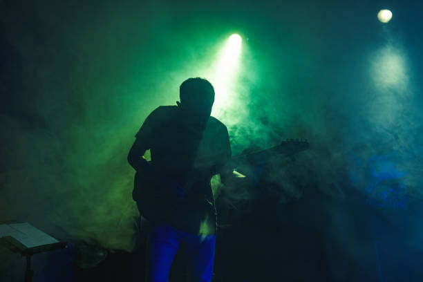 istock Silhouette of a guitarist on stage light and smoke effects. 2080767248