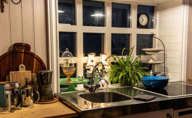 a kitchen with a window and a clock on the wall - sink domestic kitchen kitchen sink faucet imagens e fotografias de stock