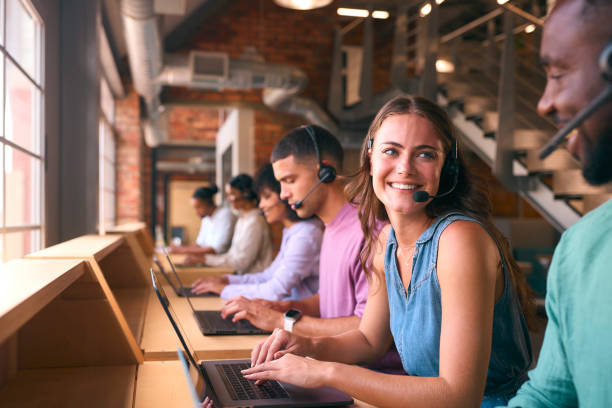 istock Multi-Cultural Customer Support Or Telesales Team In Modern Open Plan Office Wearing Headsets 2080779779