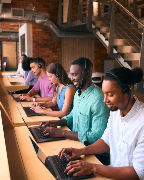 istock Multi-Cultural Customer Support Or Telesales Team In Modern Open Plan Office Wearing Headsets 2080786111