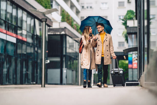 istock beautiful young couple walking in the rain 2080787698