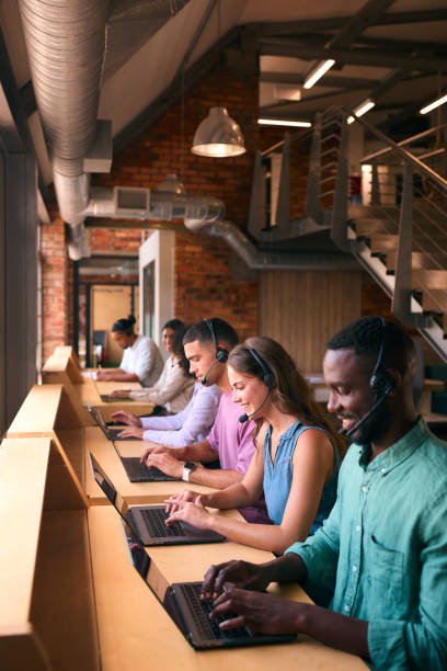istock Multi-Cultural Customer Support Or Telesales Team In Modern Open Plan Office Wearing Headsets 2080788253