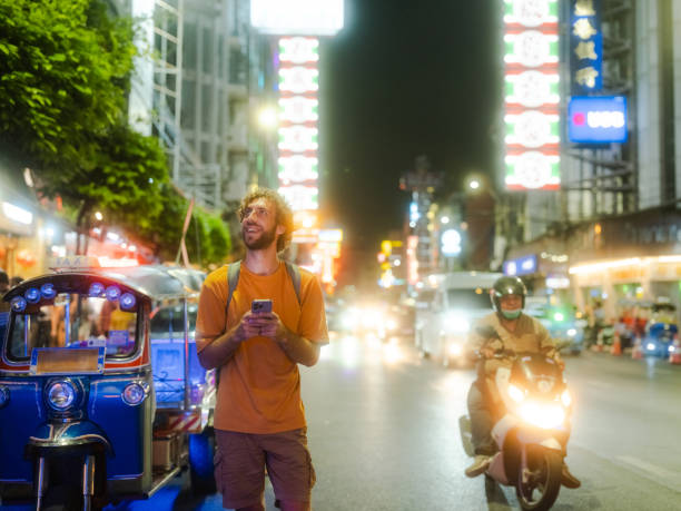 istock Man using smartphone while walking in Chinatown in Bangkok 2080810527