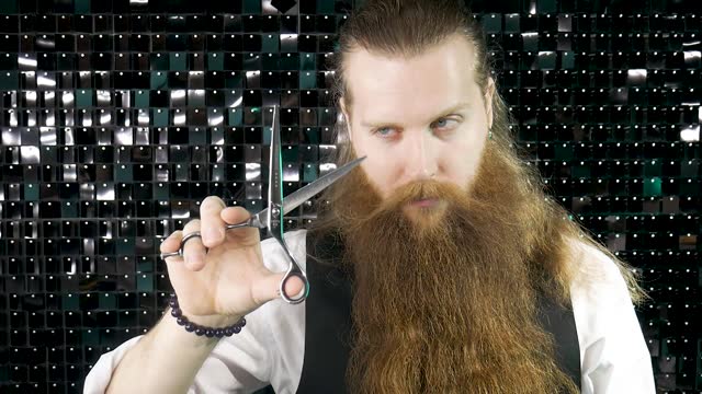 Bearded barber portrait with scissors