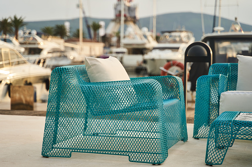 Wicker blue chairs and a table. Summer outdoor furniture on the seashore. High quality photo