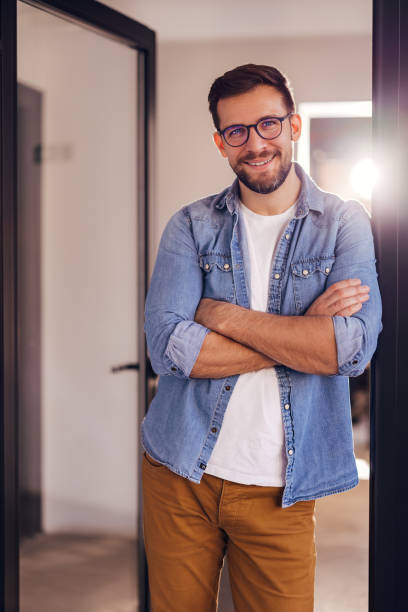 istock Young confident entrepreneur standing in modern office smiling and looking at camera. 2080829030