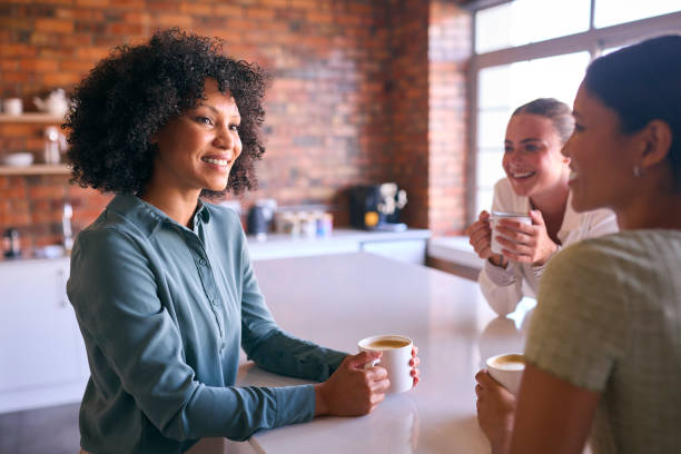 istock Multi-Cultural Businesswomen Taking Coffee Break In Kitchen Area Of Modern Open Plan Office Together 2080856723