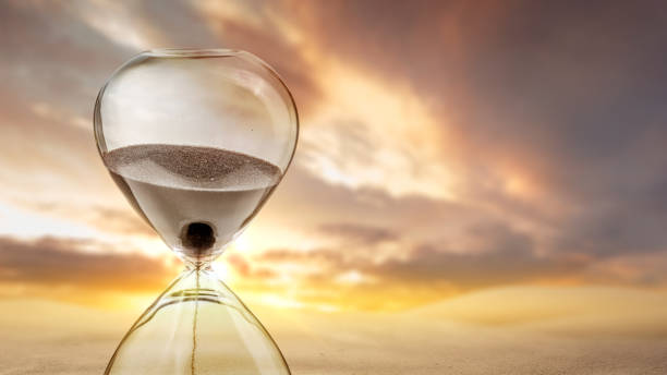 Flowing sand in the hourglass stock photo
