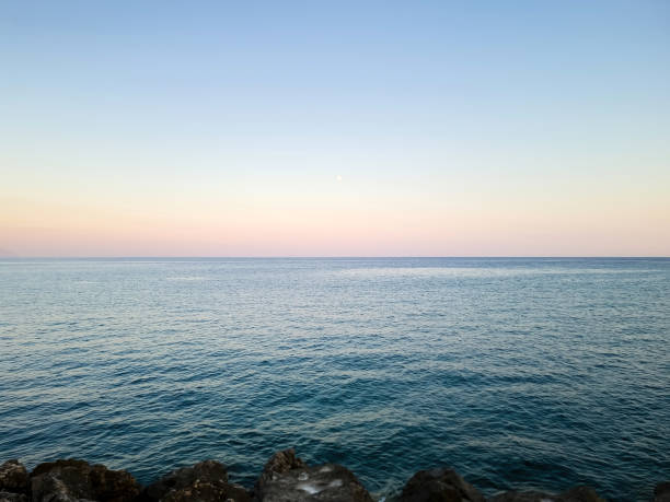 istock Rippled empty sea, purple, pink, blue sky background texture. Afternoon at rocky beach, copy space. 2080884214
