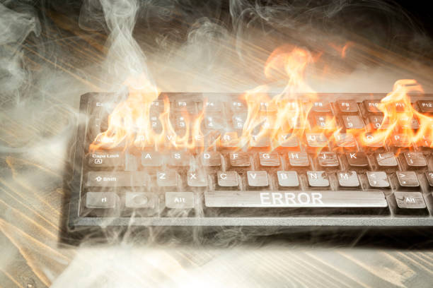 istock Computer keyboard burned with flame and smokes on wooden desk. 2080896732