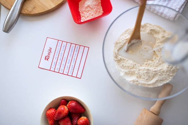 A mid adult Caucasian woman making dough for a cake in the kitchen of her apartment