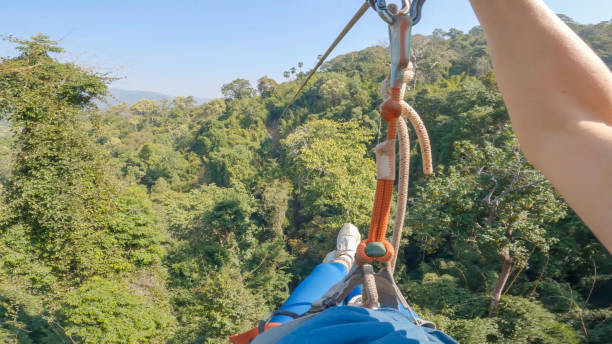 through the treetops: a woman's pov zip-lining adventure in laos' rainforest - ziplining zip line outdoors zip lining stock-fotos und bilder