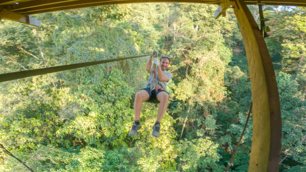 istock Young man zip lining over the jungle in Laos 2080909442