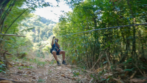 istock Young man zip lining over the jungle in Laos 2080909447