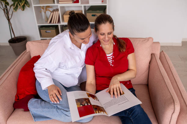istock Two women reading a magazine at home 2080911366