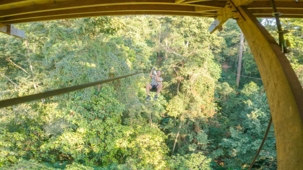 istock Young man zip lining over the jungle in Laos 2080911564