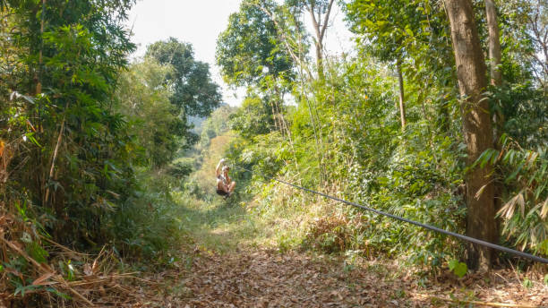 istock Young man zip lining over the jungle in Laos 2080912173