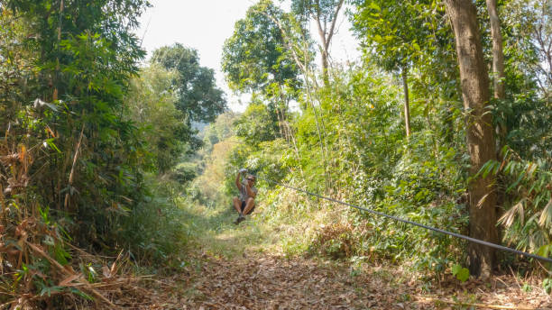 istock Young man zip lining over the jungle in Laos 2080912636
