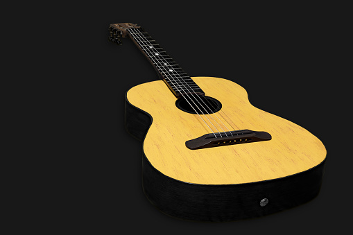 Acoustic guitar on a dark background. Musical string instrument.