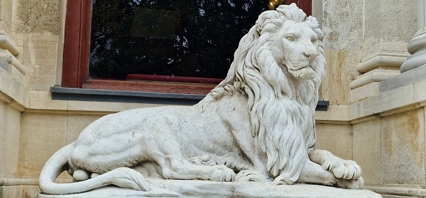 two statues of lions guard a villa
