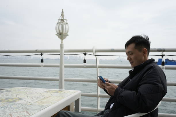 A man uses his mobile phone to work in a seaside restaurant
