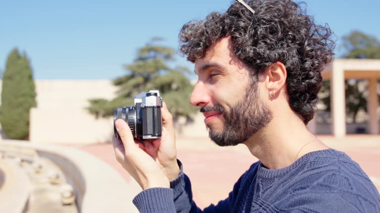 Young man taking photo with vintage camera