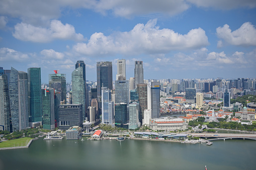 Singapore, Singapore - August 22, 2019: Skyline of the financial district, with Raffles Place skyscrapers (including One Raffles Place, UOB Plaza and OCBC Centre), towering over shophouses at Boat Quay along the Singapore River.