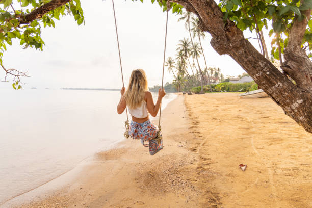 istock Young woman plays swing on a wild beach 2080973540