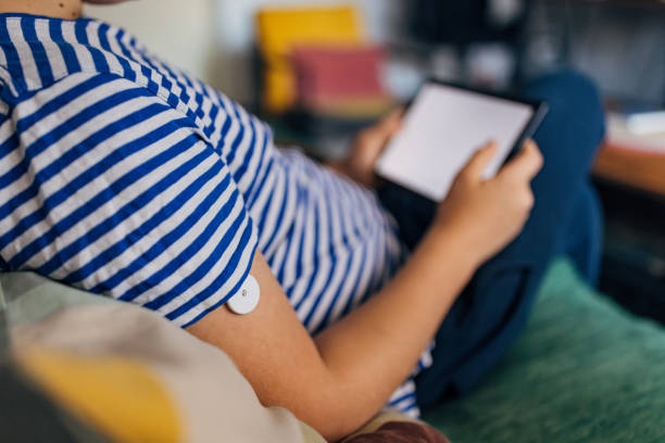 istock Unrecognizable boy with diabetes wearing a small glucose sensor and using a digital tablet at home 2080979103