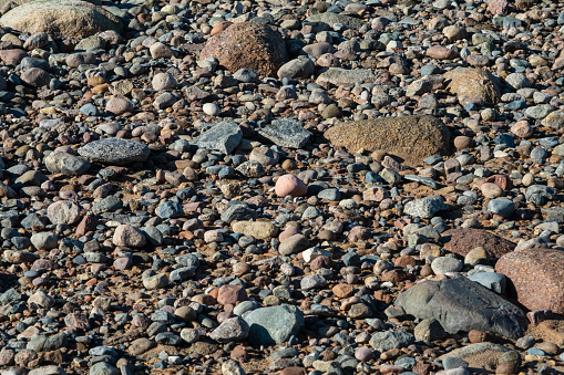 Close-up view of a rocky surface with variously sized and colored pebbles.