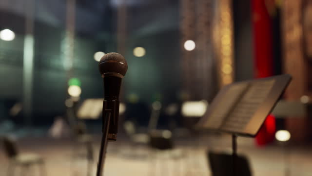 A microphone that is sitting in front of a music stand
