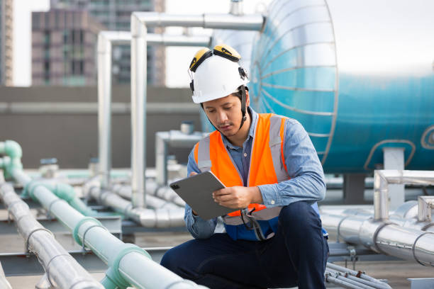 istock Asian male engineer working at construction site area. Male engineer worker standing near sewer pipes or water tank area. Asian male plumber worker maintenance sewer pipes network system 2080994724