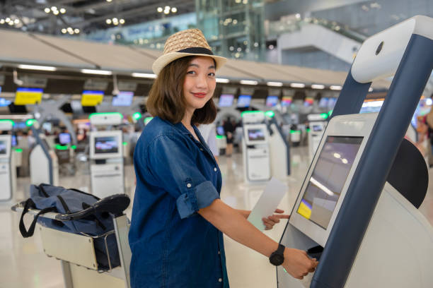 istock young attractive asian woman doing self check in at self service check in machine or KIOSK at the airport 2081059010