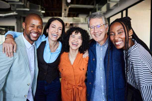 istock Diverse businesspeople laughing while standing arm in arm together at work 2081097771