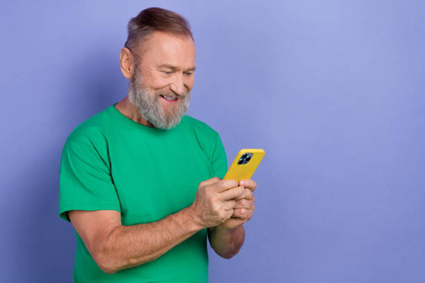 istock Photo of positive aged man use smart phone typing texting empty space isolated on violet color background 2081099403