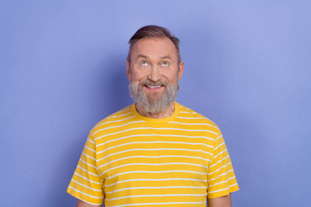 istock Photo of cheerful minded creative man beaming smile look interested up empty space isolated on violet color background 2081099435