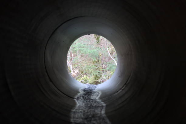 istock View through a round tunnel carrying a stream beneath a road 2081115983