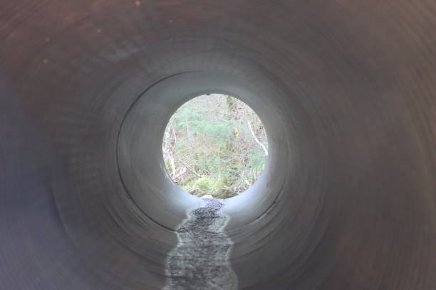 istock View through a round tunnel carrying a stream beneath a road 2081116507