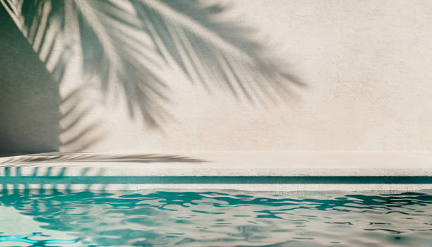 fond d’été tropical avec mur en plâtre, eau de piscine et ombre de palmier. modèle de maquette de scène au bord de la piscine d’un hôtel de luxe. - water wave sea tranquil scene photos et images de collection