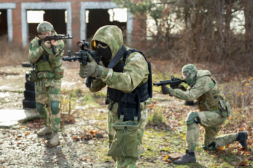 A group of soldiers in a war zone playing airsoft