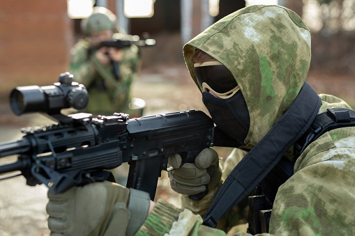 A group of soldiers in a war zone playing airsoft