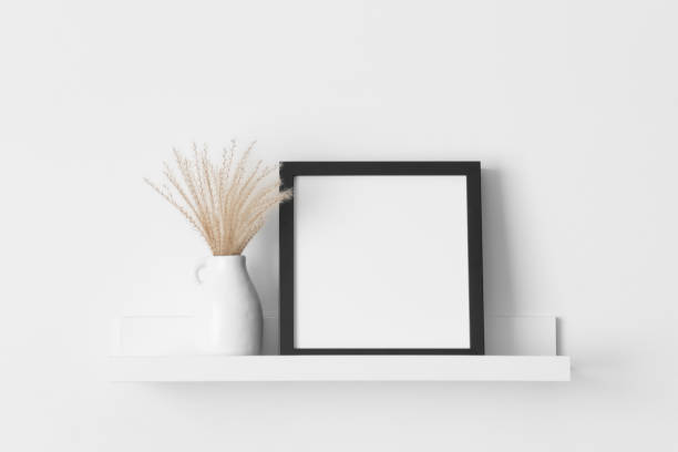 istock Black square frame mockup with a pampas decoration on the wall shelf. 2081144222
