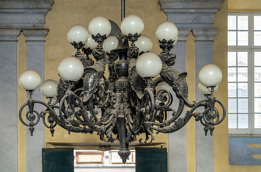 Historic dusty chandelier seen at the University of Genoa, the capital of the italian region of Liguria
