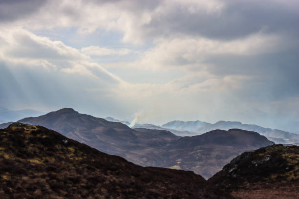 Sunlight illuminating mountain ranges in the Scottish Highlands