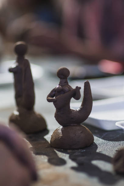 Clay figures being molded to create mermaids.
