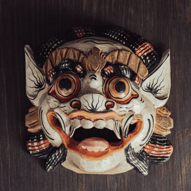 Asian ritual mask on a wooden wall background. Close up