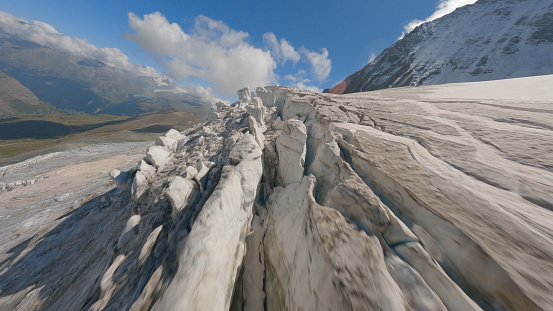 Aerial view of crevasse field on glacier leading to mountains, Swiss Alps