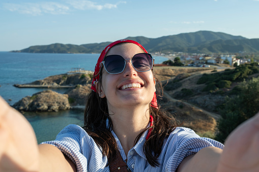 Happy young woman enjoying her vacation,taking  a selfie.
