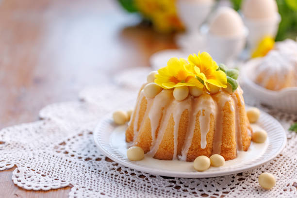 istock Easter bundt cake, Babka covered with icing, decorated with chocolate eggs and primrose flowers on a festive table, with copy space. 2081368373