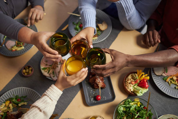 istock Family Clinking Glasses Over Dinner Table 2081375365